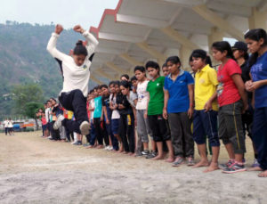 कैंप में प्रशिक्षण के दौरान ऊंची कूद लगाती एक युवती ।