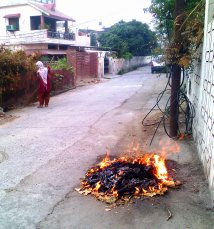 तेगबहादुर रोड बिजली दफ्तर के निकट रोज इसी तरह सफाई कर्मचारी कूड़ा उठाकर लोगों के घरों के आगे सड़क पर जला देती है ।